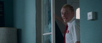 Movie still from “Shaun of the Dead” (2004), directed by Edgar Wright – A man in a white shirt and a red neck tie; Medium shot, Low angle