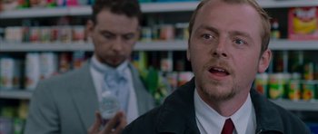 Movie still from “Shaun of the Dead” (2004), directed by Edgar Wright – A man in a suit and tie holding a cell phone; Close Up shot, Over the shoulder angle