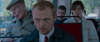 Movie still from “Shaun of the Dead” (2004), directed by Edgar Wright – A person on a bus wearing a suit and tie; Close Up shot, Over the shoulder angle