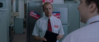 Movie still from “Shaun of the Dead” (2004), directed by Edgar Wright – A man holding a clipboard standing in front of a refrigerator; Medium shot, Low angle