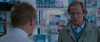 Movie still from “Shaun of the Dead” (2004), directed by Edgar Wright – Two people standing in front of a display of books; Close Up shot, Over the shoulder angle