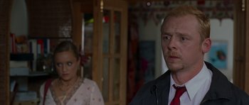 Movie still from “Shaun of the Dead” (2004), directed by Edgar Wright – A man and a woman standing in front of a wooden door; Close Up shot, Over the shoulder angle