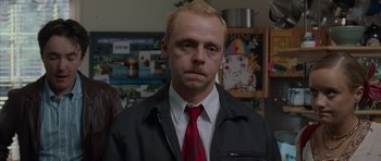 Movie still from “Shaun of the Dead” (2004), directed by Edgar Wright – A man in a black jacket and a red tie; Close Up shot, Over the shoulder angle