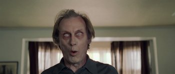 Movie still from “Shaun of the Dead” (2004), directed by Edgar Wright – A person wearing a shirt with eyes open; Close Up shot, Low angle