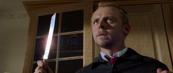 Movie still from “Shaun of the Dead” (2004), directed by Edgar Wright – A person holding a knife; Close Up shot, Low angle
