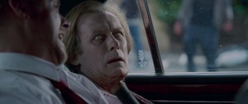 Movie still from “Shaun of the Dead” (2004), directed by Edgar Wright – A person in a car with blood on his face; Close Up shot, Over the shoulder angle