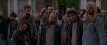 Movie still from “Shaun of the Dead” (2004), directed by Edgar Wright – A group of people that are standing in the street; Wide shot, High angle