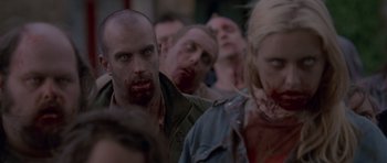 Movie still from “Shaun of the Dead” (2004), directed by Edgar Wright – A group of people that are standing in the street; Medium shot, High angle