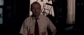 Movie still from “Shaun of the Dead” (2004), directed by Edgar Wright – A man in a white dress shirt and red tie; Medium shot, Over the shoulder angle