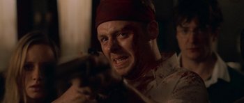 Movie still from “Shaun of the Dead” (2004), directed by Edgar Wright – A person holding a gun in a dark room; Close Up shot, Low angle