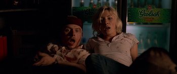 Movie still from “Shaun of the Dead” (2004), directed by Edgar Wright – A man and a woman sitting next to each other on a couch; Medium shot, Low angle