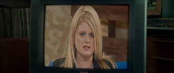 Movie still from “Shaun of the Dead” (2004), directed by Edgar Wright – A woman with blonde long hair sitting in front of a television; Close Up shot, Over the shoulder angle