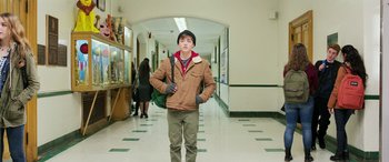 Movie still from “Shazam!” (2019), directed by David F. Sandberg – A young man standing in a hallway with his hands in his pockets; Wide shot, Low angle