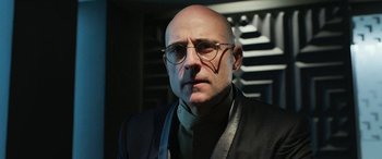 Movie still from “Shazam!” (2019), directed by David F. Sandberg – A bald man wearing glasses and a black jacket; Close Up shot, Low angle