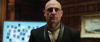 Movie still from “Shazam!” (2019), directed by David F. Sandberg – A bald man wearing glasses and a black jacket; Close Up shot, Low angle