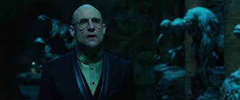 Movie still from “Shazam!” (2019), directed by David F. Sandberg – A bald man in a black suit and glasses; Close Up shot, Low angle