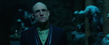 Movie still from “Shazam!” (2019), directed by David F. Sandberg – A man with bald head wearing glasses and a suit; Close Up shot, Low angle