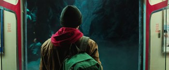 Movie still from “Shazam!” (2019), directed by David F. Sandberg – A person with a backpack looking into a cave; Medium shot, Low angle