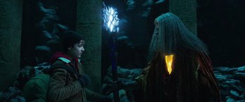 Movie still from “Shazam!” (2019), directed by David F. Sandberg – A man in a costume holding a staff in front of another man; Medium shot, Over the shoulder angle