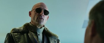 Movie still from “Shazam!” (2019), directed by David F. Sandberg – A bald man wearing sunglasses and a leather jacket; Close Up shot, Low angle