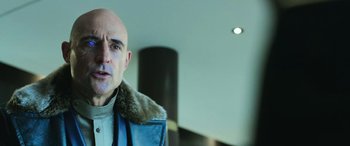 Movie still from “Shazam!” (2019), directed by David F. Sandberg – A bald man wearing a blue jacket with a fur collar; Close Up shot, Low angle