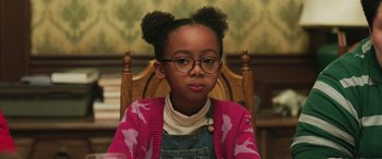 Movie still from “Shazam!” (2019), directed by David F. Sandberg – A little girl sitting in a chair wearing glasses; Close Up shot, Over the shoulder angle