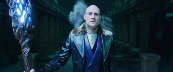 Movie still from “Shazam!” (2019), directed by David F. Sandberg – A bald man wearing a leather jacket and a fur collar; Close Up shot, Low angle