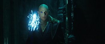 Movie still from “Shazam!” (2019), directed by David F. Sandberg – A bald man with blue eyes wearing a leather jacket; Medium shot, Low angle