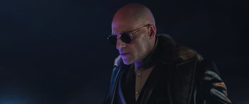 Movie still from “Shazam!” (2019), directed by David F. Sandberg – A bald man wearing sunglasses and a leather jacket; Close Up shot, Low angle