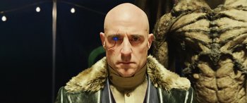 Movie still from “Shazam!” (2019), directed by David F. Sandberg – A bald man with a blue eye is wearing a fur coat; Close Up shot, Low angle