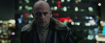 Movie still from “Shazam!” (2019), directed by David F. Sandberg – A bald man wearing a leather jacket and a fur coat; Close Up shot, Over the shoulder angle