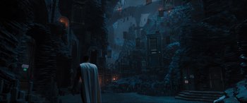 Movie still from “Shazam! Fury of the Gods” (2023), directed by David F. Sandberg – A man standing in front of a building in the dark; Extreme Wide shot, High angle