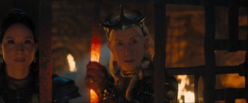 Movie still from “Shazam! Fury of the Gods” (2023), directed by David F. Sandberg – A woman holding a sword in front of a fire pit; Close Up shot, Low angle