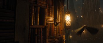 Movie still from “Shazam! Fury of the Gods” (2023), directed by David F. Sandberg – A lamp hanging from the side of an old book shelf; Wide shot, Low angle
