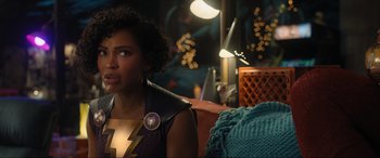 Movie still from “Shazam! Fury of the Gods” (2023), directed by David F. Sandberg – A woman sitting on a chair in a room; Medium shot, Over the shoulder angle