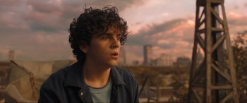 Movie still from “Shazam! Fury of the Gods” (2023), directed by David F. Sandberg – A young man with curly hair is looking at the sky; Close Up shot, Over the shoulder angle