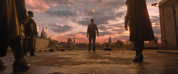 Movie still from “Shazam! Fury of the Gods” (2023), directed by David F. Sandberg – A man standing on the ground in front of a city; Extreme Wide shot, Low angle