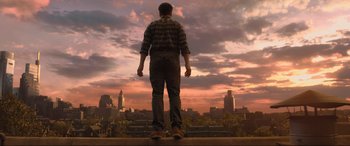Movie still from “Shazam! Fury of the Gods” (2023), directed by David F. Sandberg – A man standing on a ledge looking out over a city; Wide shot, Low angle