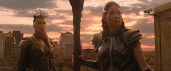 Movie still from “Shazam! Fury of the Gods” (2023), directed by David F. Sandberg – A woman dressed as a warrior holding onto a pole; Medium shot, Low angle