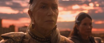 Movie still from “Shazam! Fury of the Gods” (2023), directed by David F. Sandberg – An older woman wearing a necklace looking at the camera; Close Up shot, Low angle