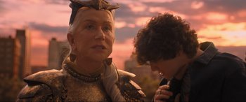 Movie still from “Shazam! Fury of the Gods” (2023), directed by David F. Sandberg – An older woman wearing a suit of armor with a young man looking at her; Close Up shot, Over the shoulder angle