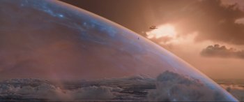 Movie still from “Shazam! Fury of the Gods” (2023), directed by David F. Sandberg – An airplane flying over a large body of water at sunset; Extreme Wide shot, High angle