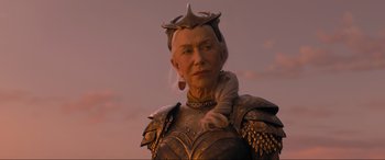 Movie still from “Shazam! Fury of the Gods” (2023), directed by David F. Sandberg – An older woman wearing a golden armor with a crown on her head; Close Up shot, Low angle