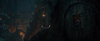 Movie still from “Shazam! Fury of the Gods” (2023), directed by David F. Sandberg – A dark cave with stairs leading up to a building; Extreme Wide shot, High angle