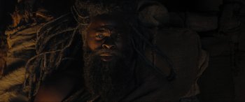 Movie still from “Shazam! Fury of the Gods” (2023), directed by David F. Sandberg – A man with long dreadlocks and a long beard; Close Up shot, Low angle