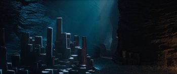Movie still from “Shazam! Fury of the Gods” (2023), directed by David F. Sandberg – A dark room filled with lots of rocks and water; Extreme Wide shot, High angle