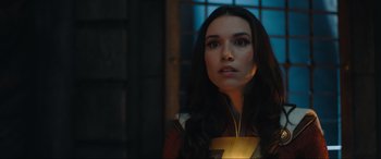 Movie still from “Shazam! Fury of the Gods” (2023), directed by David F. Sandberg – A woman with long black hair is looking at the camera; Close Up shot, Over the shoulder angle