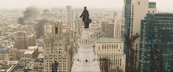 Movie still from “Shazam! Fury of the Gods” (2023), directed by David F. Sandberg – A man standing on the top of a white building; Extreme Wide shot, High angle
