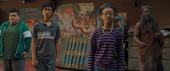 Movie still from “Shazam! Fury of the Gods” (2023), directed by David F. Sandberg – A boy and a girl standing next to each other in front of graffiti; Medium shot, Low angle