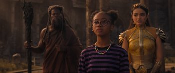 Movie still from “Shazam! Fury of the Gods” (2023), directed by David F. Sandberg – A young girl wearing a striped shirt and glasses; Medium shot, Over the shoulder angle